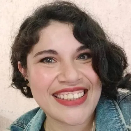 Wendolyn Vázquez - Mujer sonriente con cabello corto y chaqueta de mezclilla.